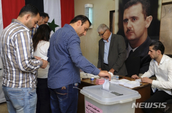 시리아 관영 사나 통신 제공으로, 지난 9월16일 수도 다마스쿠스에서 시의회 선거 투표가 실시되고 있다. 아사드 대통령 사진이 보인다. /사진=뉴시스