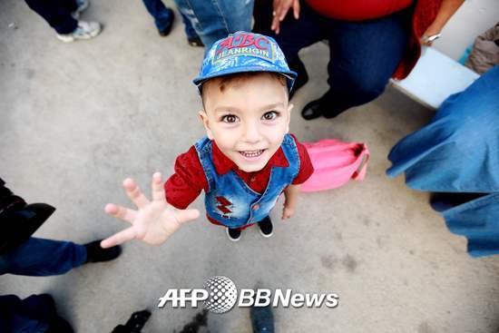 시리아인 아이가 지난 9월17일 카메라를 향해 웃고 있다. 아이는 몇년 간 레바논에 위치한 시리아 난민 캠프에서 지내왔다가 이날 가족과 함께 본국으로 돌아갔다. 시리아 내전이 거의 종식되는 단계여서다. /AFPBBNews=뉴스1