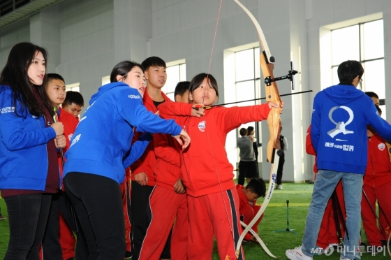현대모비스 여자 양궁단 선수들이 중국 톈진 지역 초·중학교 어린이들을 대상으로 한 어린이 양궁 교실에서 활 쏘는 법을 지도하고 있다. /사진제공=현대모비스