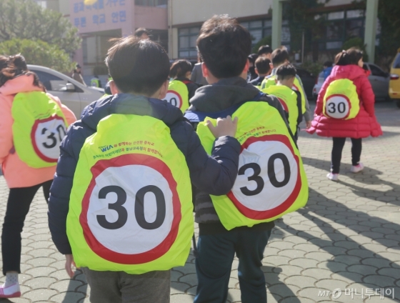 지난 20일 경남 창원시 성산구 안민초등학교에서 학생들이 어린이용 안전 가방 덮개를 씌운 가방을 메고 하교하고 있다./사진=현대위아