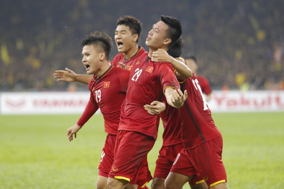 【쿠알라룸푸르=AP/뉴시스】베트남 축구대표팀 응우옌 후이흥(29번)이 11일(현지시간) 말레이시아 쿠알라룸푸르 부킷 잘릴 국립경기장에서 열린 스즈키컵 결승 1차전 전반 22분 선취골을 기록하고 동료들과 기뻐하고 있다. 2018.12.11.<br>
