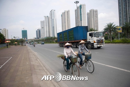 지난 9월12일 베트남 하노이에서 두 여성이 자전거를 타고 가고 있다./AFPBBNews=뉴스1
