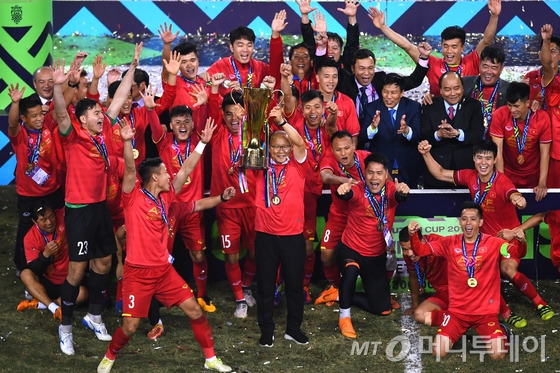 박항서 감독(가운데)이 지난 15일(한국시간) 베트남 하노이의 미딩 국립경기장에서 2018 아세안축구연맹(AFF) 스즈키컵 우승 트로피를 들어 올리고 있다. /AFP=뉴스1