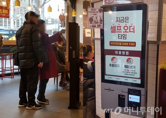 지난 19일 서울 종로구의 한 패스트푸드 전문점. 60대 고객이 '셀프 오더 타임'에 무인 주문기로 주문을 넣다 주변인에게 도움을 청하고 있다. /사진=박가영 기자 