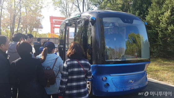 세계 첫 AI공원으로 새롭게 개장한 중국 베이징시 하이뎬공원에서 시민들이 무인 자율 주행 버스 아폴로를 타기 위해 기다리고 있다.
