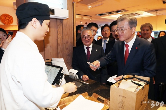 문재인 대통령이 24일 대전 성심당 빵집에서 온누리상품권으로 결제하고 있다./청와대 제공