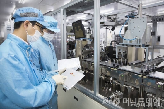 SK이노베이션 서산공장 전기차 배터리 생산라인에서 직원들이 생산된 배터리 셀을 검사하고 있다.