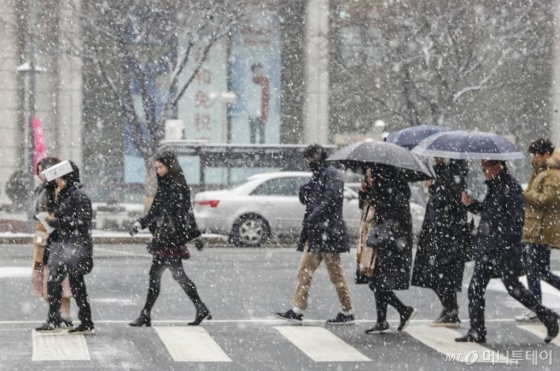 중부지방 곳곳에 눈이 내린 15일 오전 서울 세종대로 광화문광장 인근에서 시민들이 발걸음을 재촉하고 있다./사진=이기범 기자