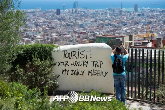 2017년 8월10일 스페인 바르셀로나에서 찍힌 사진. 바르셀로나시가 내려다보이는 위치 한 벽면에 "관광객 여러분, 당신의 호화스런 여행은 내 일상의 고통입니다"라는 글귀가 적혀있다. /AFPBBNews=뉴스1