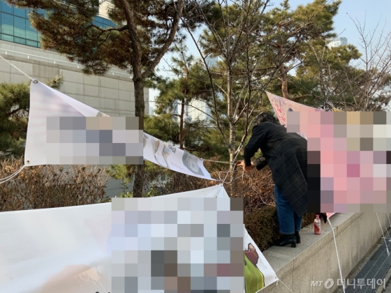 졸업식이 끝난 후 현수막을 자진 철거하는 모습./사진=한민선 기자