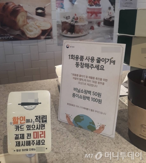 지난 1월 1일 오전 서울의 한 프랜차이즈 제과점 계산대에 '1회용 비닐 봉투 유상 제공' 관련 안내문이 올려져 있는 모습./사진=머니투데이 DB