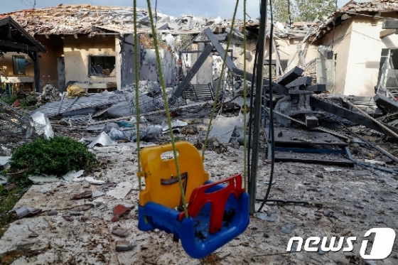 이스라엘 텔아비브 근교 미시메렛 마을에 25일(현지시간) 로켓포가 떨어져 주택이 불에 탔다. © AFP=뉴스1