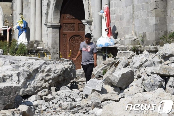 23일(현지시간) 필리핀에서 규모 6.1의 지진이 발생한 가운데 마닐라 북쪽 팜팡가 포락 타운의 교회 종탑이 무너져 돌무더기가 쌓여있다. 사진=뉴스1.