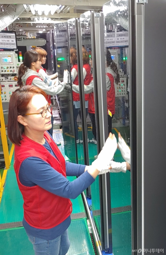 LG전자 직원들이 지난 24일 경남 창원사업장에서 최대 6벌의 옷을 한번에 관리할 수 있는 대용량 제품인 ‘트롬 스타일러 블랙에디션’을 생산하고 있다./사진제공=LG전자