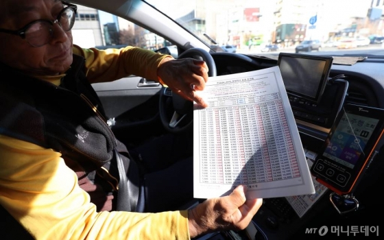 지난 2013년 10월 이후 5년 4개월만에 택시요금이 인상된지 이틀째인 지난 2월17일 오전 서울 시내의 한 택시기사가 요금 조견표를 설명하고 있다./사진=김휘선 기자 hwijpg@