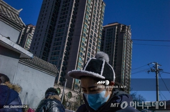 베이징에 위치한 한 아파트 앞을 사람들이 지나가고 있다/사진제공=AFP