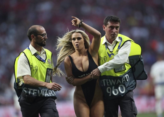 1일(현지시간) 스페인 마드리드의 에스타디오 메트로폴리타노에서 열린 2018-19 UEFA 챔피언스리그 토트넘과 리버풀(잉글랜드)과의 결승전 도중 한 여성이 운동장에 뛰어 들어 보안요원들이 여성을 끌고 나가고 있다./사진=AP=뉴시스