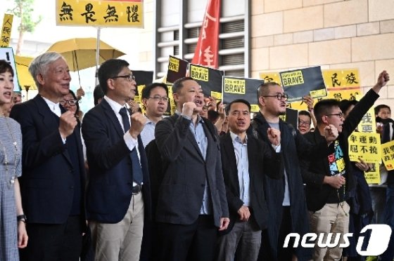 찬킨만 홍콩중문대 교수와 추이우밍 목사 등 9명의 2014년 홍콩 우산혁명 지도자들이 지난4월9일 홍콩의 법원에 출두하기 전에 구호를 외치고 있다. / AFP=뉴스1