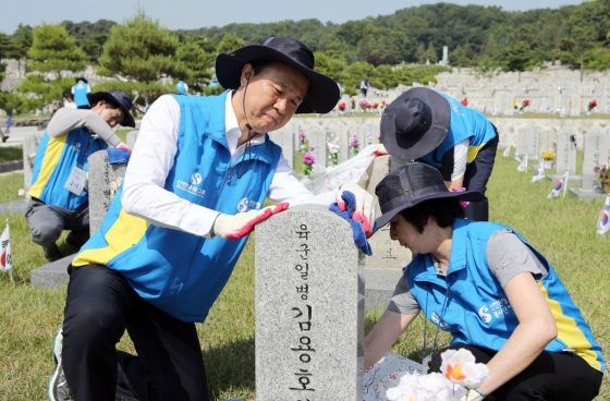 진옥동 신한은행장(앞줄 왼쪽)과 임직원들이 12일 서울시 동작구 국립서울현충원에서 순국선열들의 묘역을 정비하고 있다. / 사진제공=신한은행