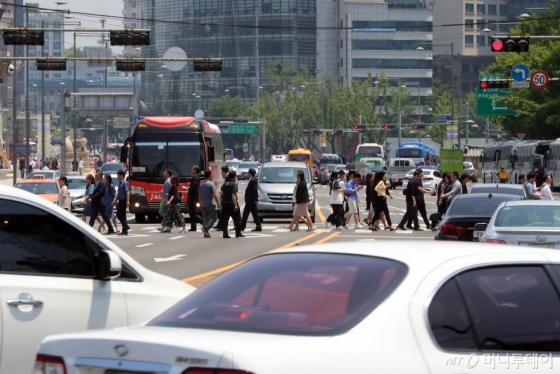 13일 오후 서울 중구 정부종합청사 주변을 지나는 시민들과 차량들. /사진=임성균 기자