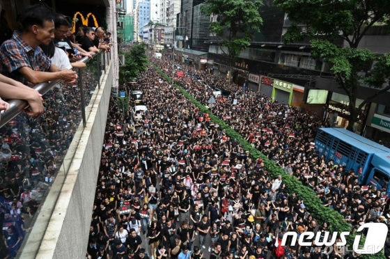 (홍콩 AFP=뉴스1) 우동명 기자 =  16일(현지시간) 범죄인 인도법 철회를 주장하는 홍콩 시민들이 검은색 옷을 입고 대규모 시위를 벌이고 있다. 이날 시위는 200만명이 참여해 이번 사태 이후 최대 규모로, 범죄인 인도법 완전 철회와 캐리 람 홍콩 행정장관의 퇴진을 요구하며 시내 곳곳에서 '검은 대행진'을 벌였다.   © AFP=뉴스1  <저작권자 © 뉴스1코리아, 무단전재 및 재배포 금지>