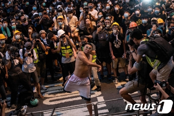 21일 한 홍콩 시민이 경찰의 과잉진압에 항의하며 경찰본부에 달걀을 투척하고 있다. © AFP=뉴스1