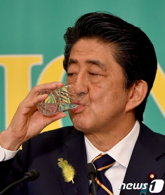 아베 신조 일본 총리 겸 자민당 총재가 3일 일본기자클럽 초청 여야 7당 당수 토론회에서 물을 마시고 있다. © AFP=뉴스1