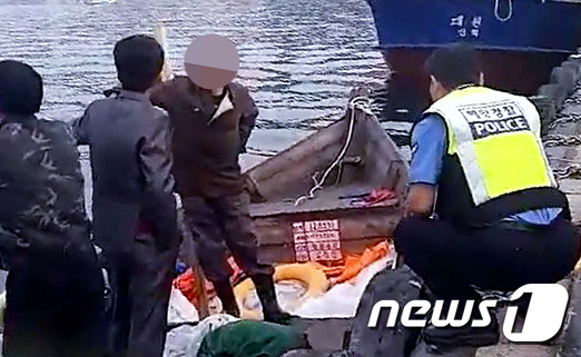 지난달 15일 북한 선원 4명이 탄 어선이 연안에서 조업 중인 어민의 신고로 발견됐다. 사진은 당시 삼척항 부두에 정박한 북한어선과 어민이 경찰에 조사받는 모습. (독자 제공) / 사진 = 뉴스1 