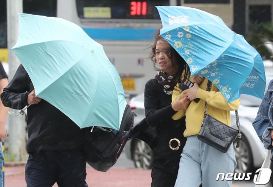 호우·강풍특보가 내려진  한 거리에서 시민들이 우산을 쓰고 걷고 있다. 사진=뉴스1