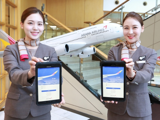 서울 강서구 오쇠동 아시아나항공 본사에서 아시아나항공 캐빈승무원들이 새롭게 지급받은 태블릿 PC를 들어보이고 있다./사진제공=아시아나항공