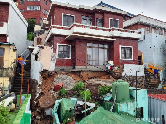  부산지역에 호우·강풍특보가 발령된 20일 오후 부산 영도구의 한 주택 마당이 무너졌다.   /사진=뉴시스