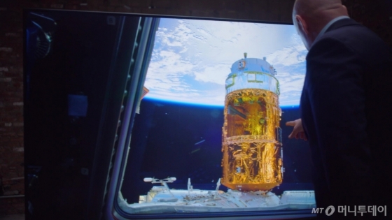 삼성전자가 달 착륙 50주년을 맞아 ‘QLED 8K로 본 우주’라는 콘셉트로 영상을 제작해 20일 공개했다. 사진은 이 영상 속의 한 장면으로 스콧 켈리가 우주에서 촬영한 지구의 모습을 삼성전자 QLED 8K TV로 감상하고 있다. /사진=삼성전자 제공<br>
