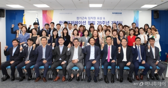 24일 한국코퍼레이션 본사에서 열린 28주년 기념식에서 임원들과 장기근속 수상자들이 기념촬영을 하고 있다.