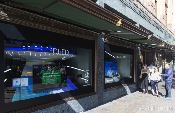 LG디스플레이가 영국 해롯백화점 1층 쇼윈도에 전시한 글로벌업체들의 OLED TV를 고객들이 둘러보고 있다./사진제공=LG디스플레이