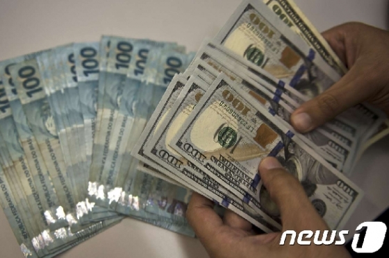 미국 100달러 지폐와 브라질 100헤알 지폐. © AFP=뉴스1
