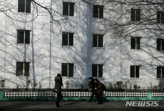 【평양=AP/뉴시스】19일 북한 주민들이 평양 시내의 한 아파트 앞을 지나고 있다. 2018.12.19     <저작권자ⓒ 공감언론 뉴시스통신사. 무단전재-재배포 금지.>