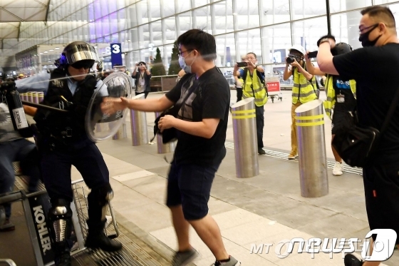  13일 (현지시간)  송환법에 반대하는 시위대가 홍콩 국제공항에서 경찰과 실랑이를 하고 있다./사진=뉴스1