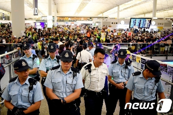 13일 (현지시간) 송환법에 반대하는 시위대가 점거하고 있는 홍콩 국제공항 입구에 경찰이 경비를 서고 있다. © AFP=뉴스1 © News1 우동명 기자