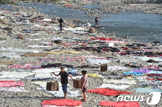 태풍 레끼마가 지나간 중국 저장성 타이저우 마을의 강둑에 주민들이 담요와 옷가지를 말리기 위해 펼쳐놓고 있다. © 로이터=뉴스1 © News1 우동명 기자