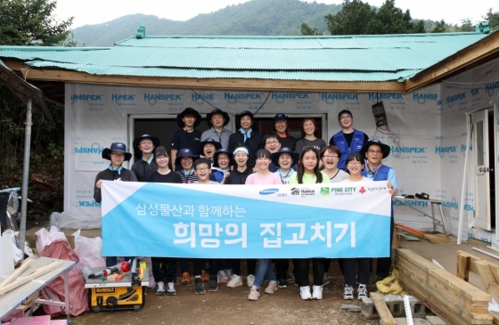 지난 14일 강릉 희망의 집고치기 봉사활동에 참여한 삼성물산 임직원 가족들이 단체사진을 촬영하고 있다./사진 제공=삼성물산<br>