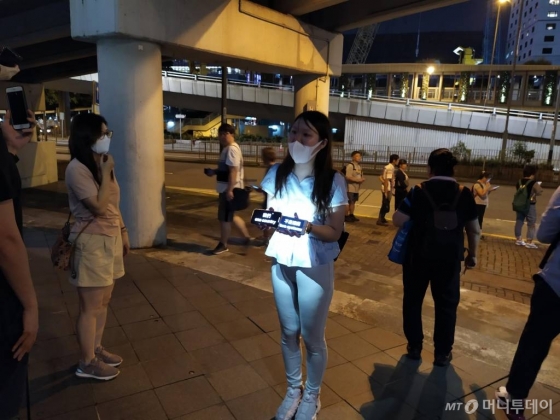 23일 홍콩에서 한 여성이 '일국양제를 지켜달라'는 메시지를 들고 시위를 하고 있다. / 사진=유희석