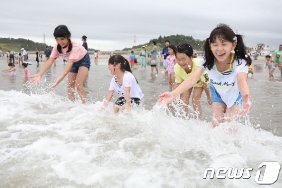 지난 7월20일 일본 방사능 누출 사고 이후 8년 만에 개장한 후쿠시마현 미나미 소마시 키타 이즈미 해수욕장에서 어린이들이 물놀이를 하고 있다.  © AFP=뉴스1