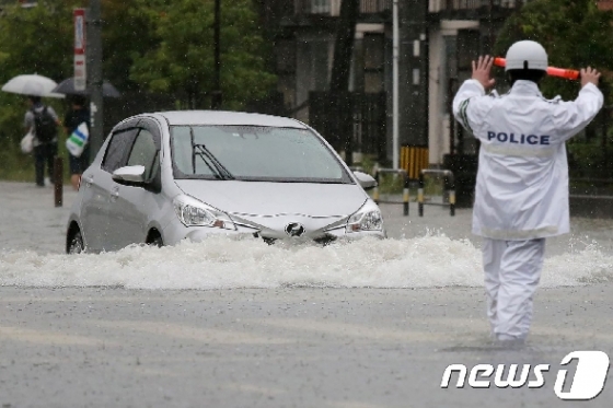 일본 규슈 지방에 쏟아진 28일 폭우로 거리가 무릎 높이까지 침수되면서 낮 12시 기준으로 주민 84만명 주민에게 대피령이 내려졌다. © AFP=뉴스1