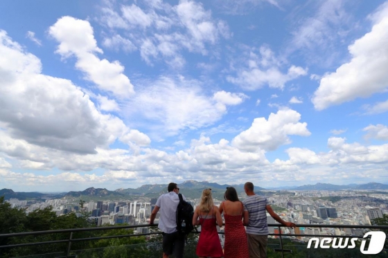 지난 7월 서울 남산을 찾은 외국인 관광객이 맑고 청명한 하늘과 서울시내를 바라보고 있다. /사진=뉴스1