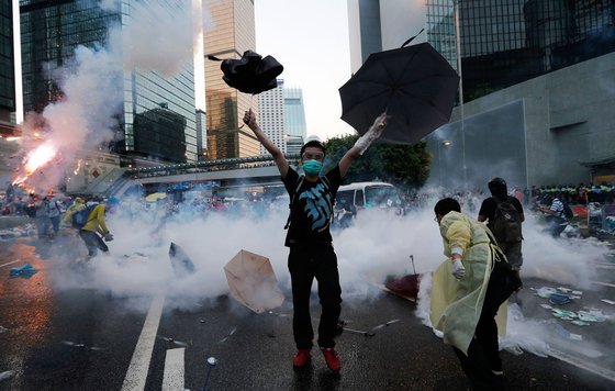 2014년 행정장관의 직선 요구하는 시위에서 한 청년이 경찰이 쏜 최루가스를 우산으로 막고 있다. © 로이터=뉴스1