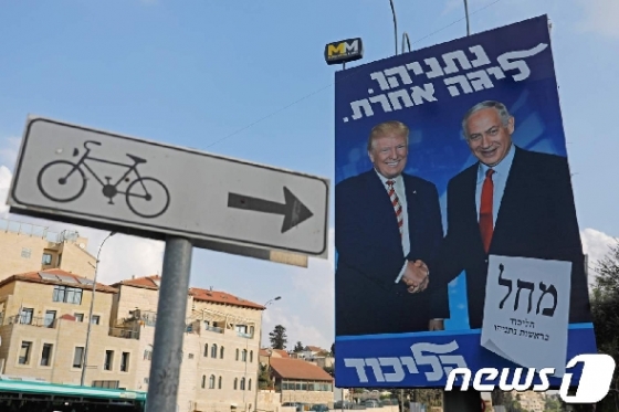 도널드 트럼프 미국 대통령과 베냐민 네타냐후 이스라엘 총리가 악수하는 사진이 거리 곳곳에 걸려 있다. © AFP=뉴스1