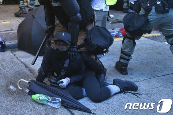 6일(현지시간) 홍콩 정부의 '복면금지법' 시행에 반대하는 복면 쓴 시위대가 진압경찰에게 체포되고 있다./사진=뉴스1