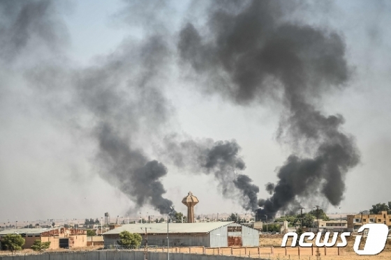 10일(현지시간) 터키군 폭격을 받은 시리아 북동부 국경지역 도시 탈 아비아드에서 검은 연기가 피어오르고 있다. © AFP=뉴스1