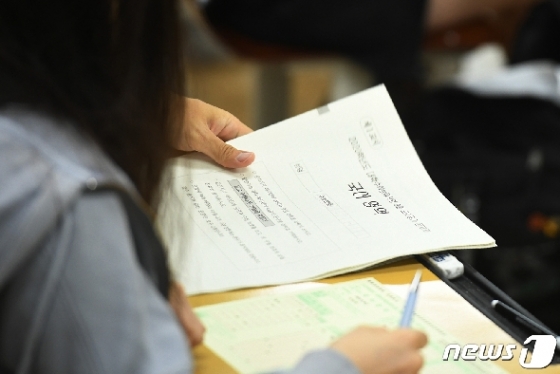 서울 영등포구 여의도여자고등학교에서 지난달 4일 '2020학년도 대학수학능력시험 9월 모의평가'에서 한 교사가 1교시 국어영역 시험지를 나눠주는 모습. /뉴스1 © News1 이재명 기자