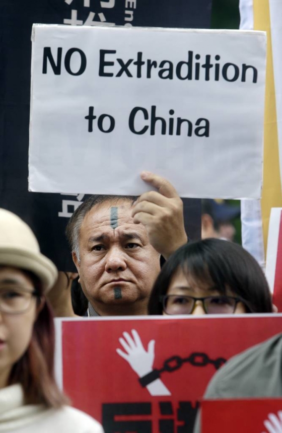 대만 타이베이의 홍콩경제무역문화사무소 앞에서 12일(현지시간) 한 남성이 '중국으로 추방 반대'라고 쓴 종이를 들고 홍콩 시민들의 범죄인 인도법 반대에 동조하는 시위를 벌이고 있다/사진=뉴시스